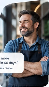 A smiling local business owner in a denim shirt and apron